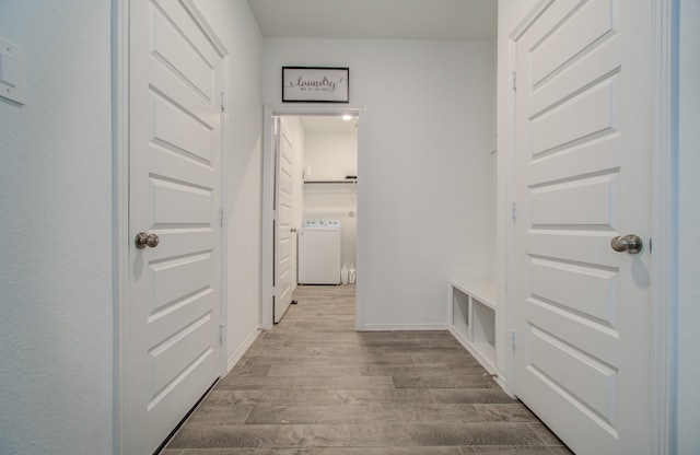 hallway featuring washer / clothes dryer and light wood-type flooring