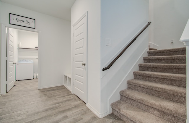 staircase with hardwood / wood-style floors and washer / dryer