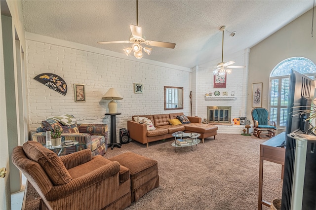 carpeted living room with a textured ceiling, a fireplace, ceiling fan, and brick wall