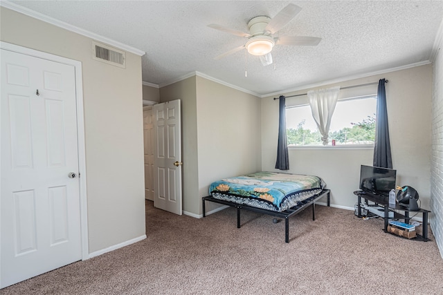 carpeted bedroom featuring ceiling fan, a textured ceiling, and ornamental molding