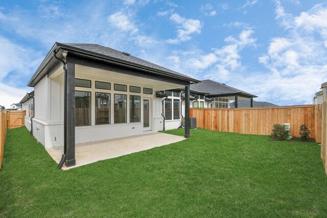 back of house featuring a yard, central air condition unit, and a patio area