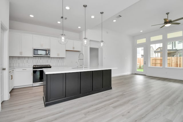 kitchen featuring appliances with stainless steel finishes, a center island with sink, white cabinetry, and sink