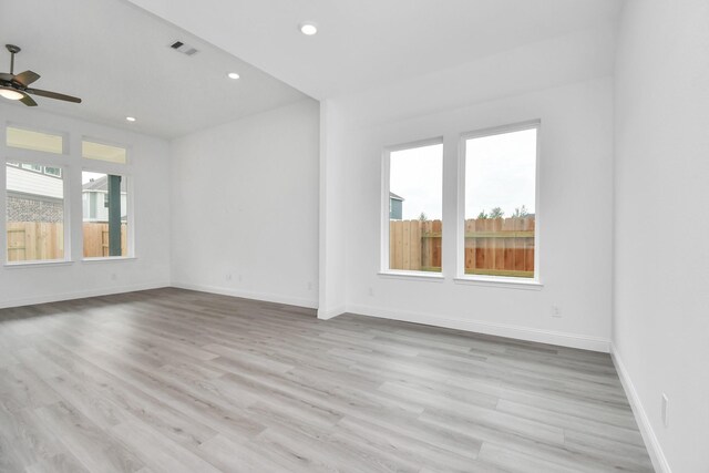 spare room with ceiling fan, light hardwood / wood-style flooring, and a wealth of natural light