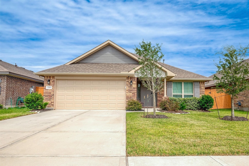 13301 Lago Acero Ln, Texas City, TX 77568 - single story home featuring fence, a garage, brick siding, a front lawn, and driveway