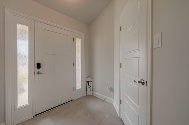 tiled foyer entrance featuring vaulted ceiling