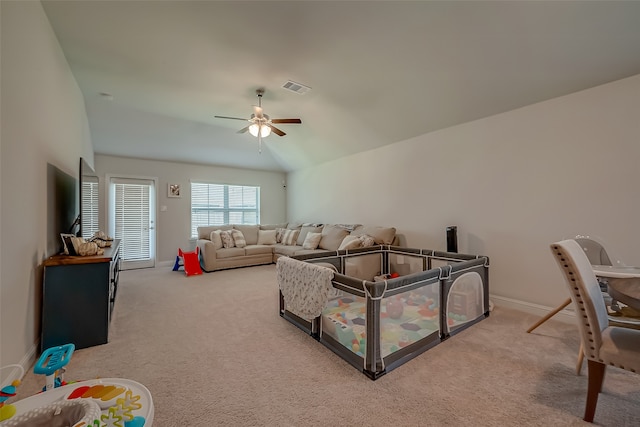 carpeted living room with ceiling fan and vaulted ceiling