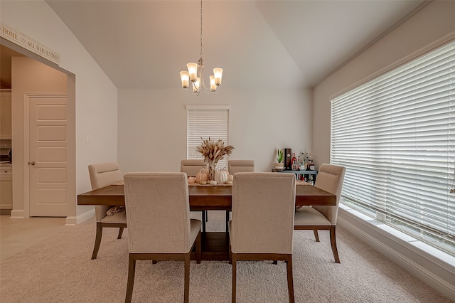 dining area with light carpet, an inviting chandelier, vaulted ceiling, and a wealth of natural light