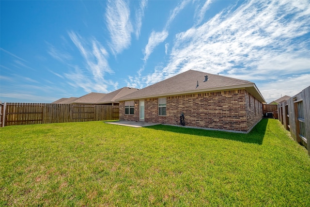 rear view of property with a lawn and a patio area