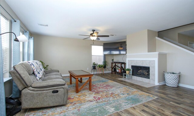 living room with a tile fireplace, ceiling fan, and hardwood / wood-style flooring