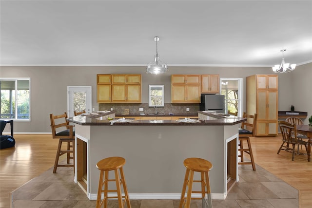 kitchen featuring light hardwood / wood-style flooring, a wealth of natural light, and hanging light fixtures