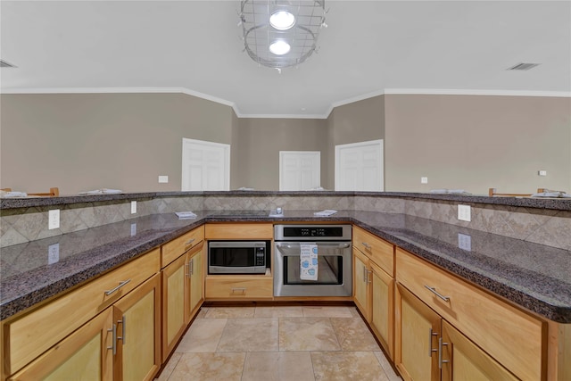 kitchen featuring dark stone countertops, crown molding, stainless steel appliances, and decorative backsplash