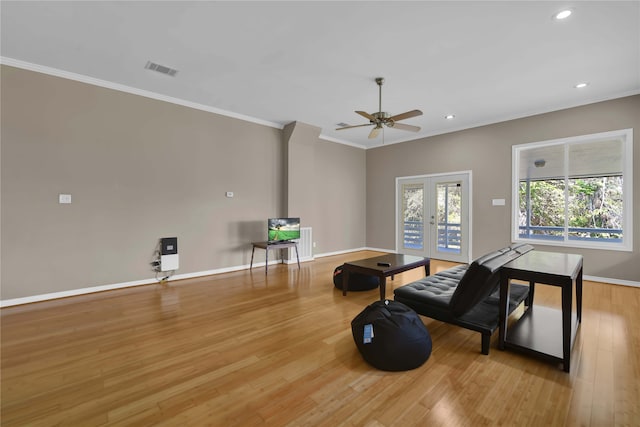 workout area featuring ornamental molding, french doors, light hardwood / wood-style flooring, and ceiling fan