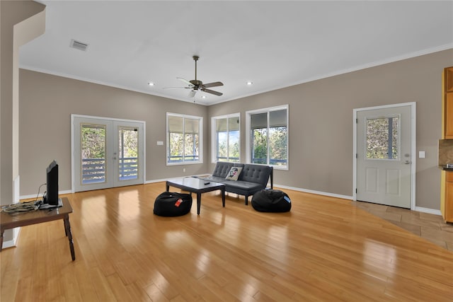 sitting room featuring light hardwood / wood-style floors, french doors, ornamental molding, and ceiling fan