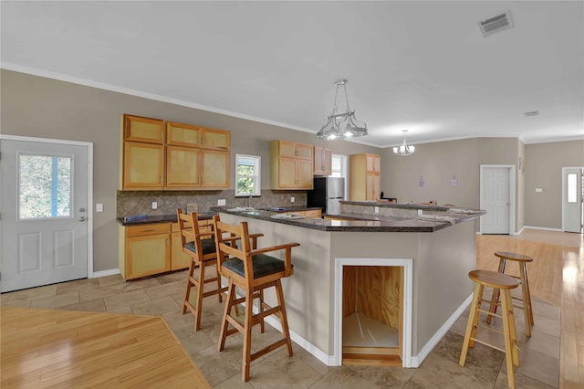 kitchen featuring a chandelier, stainless steel fridge, decorative light fixtures, and light hardwood / wood-style floors