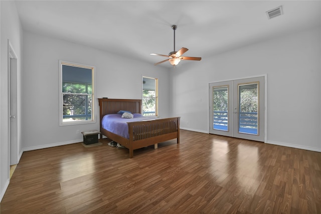 bedroom with dark hardwood / wood-style flooring, access to exterior, multiple windows, and ceiling fan