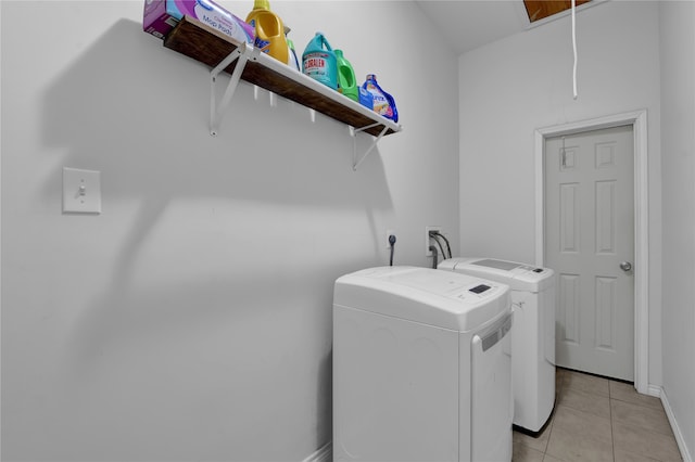 laundry room with independent washer and dryer and light tile patterned floors