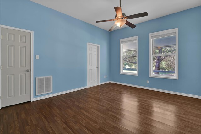 empty room with dark hardwood / wood-style floors and ceiling fan