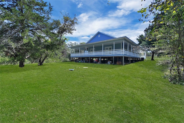 rear view of property with a yard and a sunroom