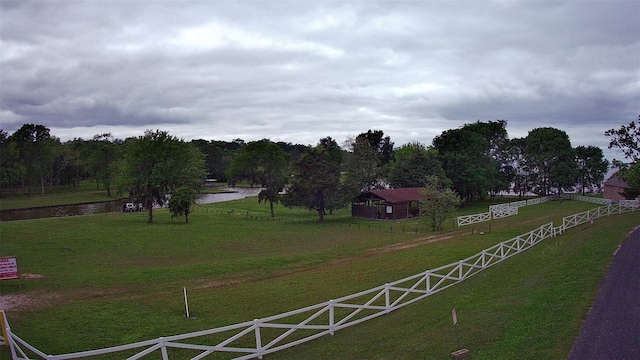 view of home's community with a yard, a water view, and a rural view