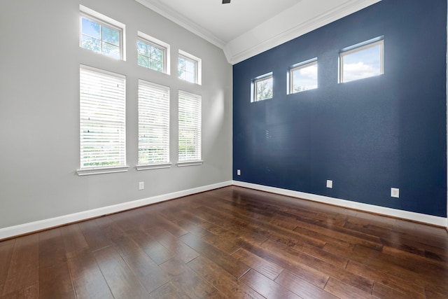 unfurnished room with a healthy amount of sunlight, ornamental molding, and dark hardwood / wood-style floors