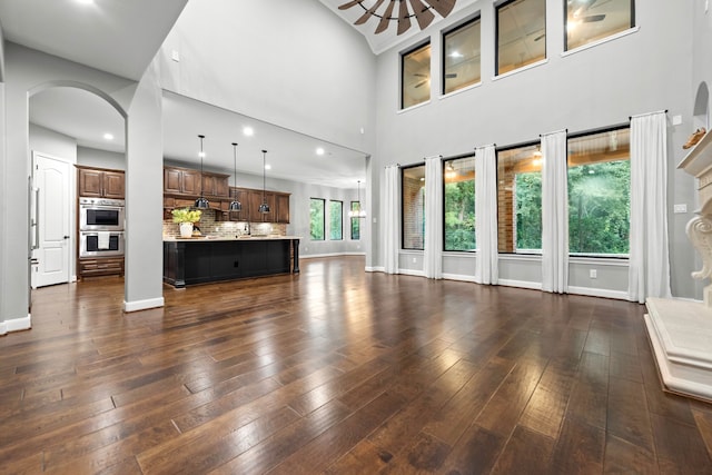 unfurnished living room with a high ceiling and dark hardwood / wood-style floors