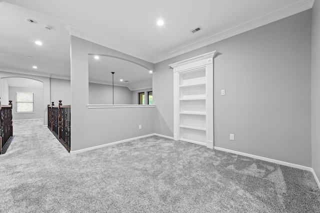 empty room featuring crown molding, carpet, and a wealth of natural light