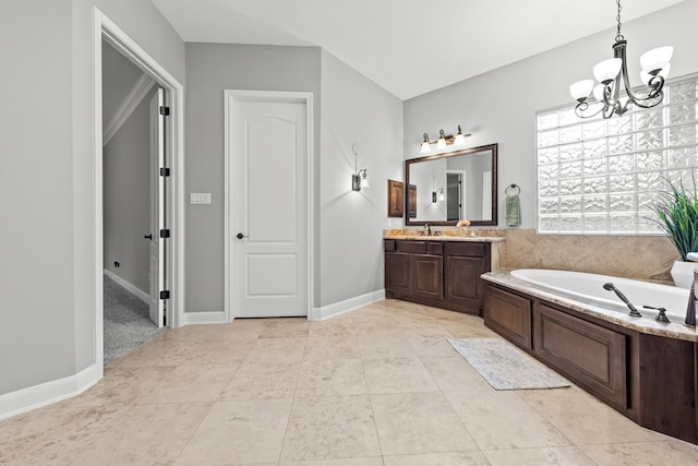 bathroom featuring tile patterned floors, a chandelier, vanity, and a bathtub