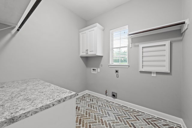 clothes washing area featuring cabinets, hookup for an electric dryer, hookup for a gas dryer, and hookup for a washing machine