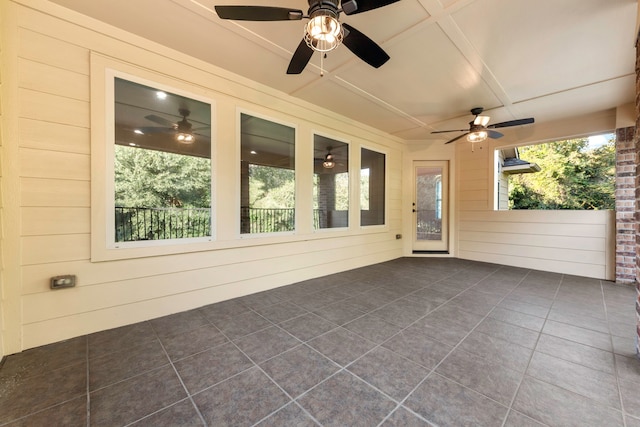 unfurnished sunroom with ceiling fan and a healthy amount of sunlight