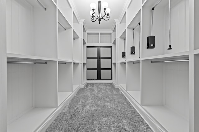 spacious closet with carpet flooring and a chandelier