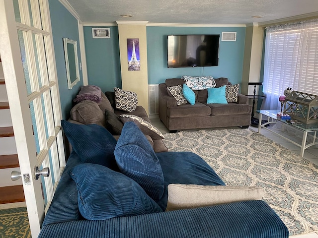 living room featuring french doors, a textured ceiling, crown molding, and tile patterned flooring