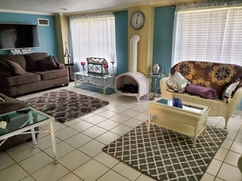 living room featuring plenty of natural light, tile patterned floors, and crown molding