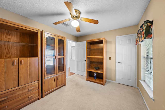 bedroom featuring a textured ceiling, ceiling fan, and light carpet