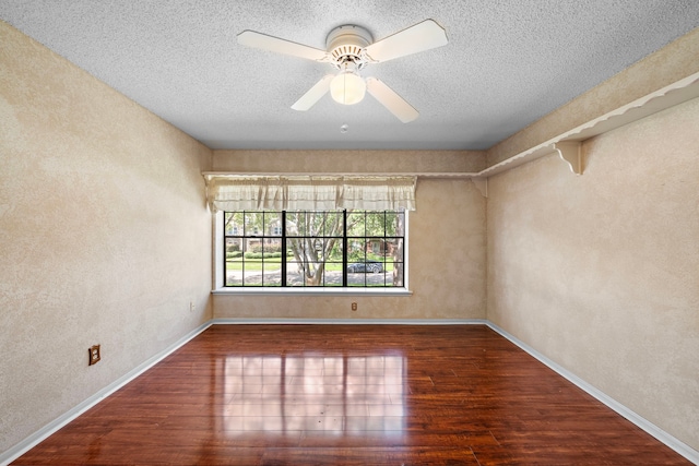 empty room featuring dark hardwood / wood-style floors, ceiling fan, and a textured ceiling