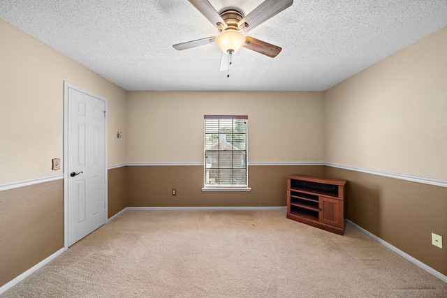 carpeted empty room featuring ceiling fan and a textured ceiling