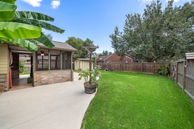 view of yard with a sunroom, a patio area, and a shed