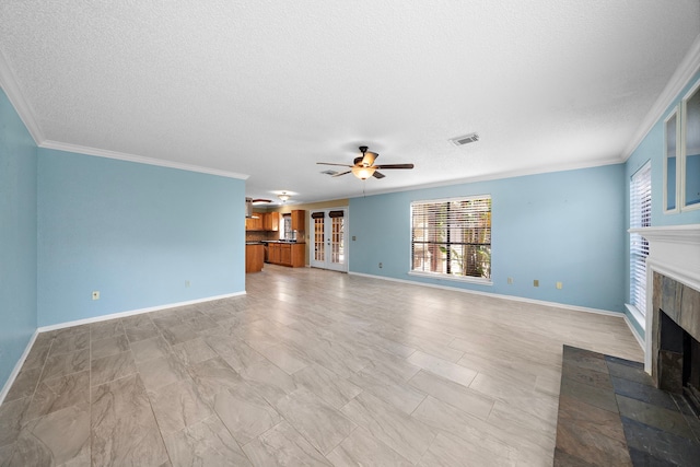 unfurnished living room with ceiling fan, ornamental molding, and a textured ceiling