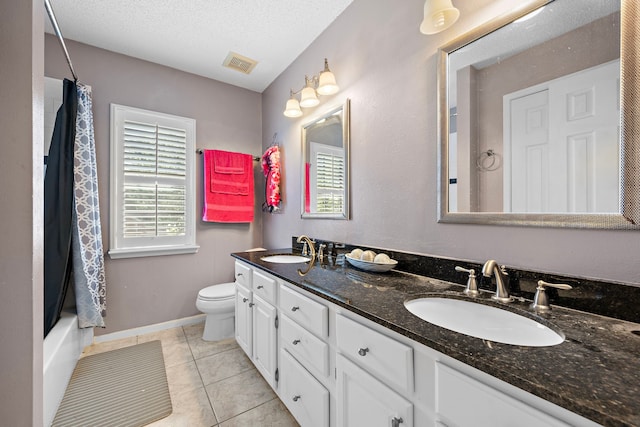 full bathroom featuring vanity, tile patterned flooring, toilet, shower / bath combo with shower curtain, and a textured ceiling