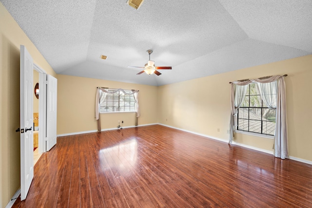 spare room with hardwood / wood-style flooring, vaulted ceiling, ceiling fan, and a healthy amount of sunlight