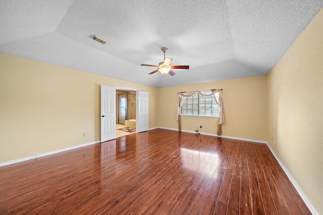 unfurnished room with lofted ceiling, ceiling fan, wood-type flooring, and a textured ceiling