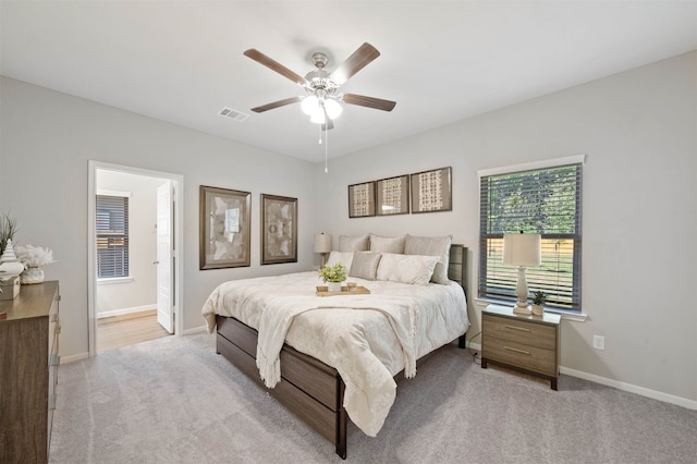 carpeted bedroom featuring connected bathroom and ceiling fan