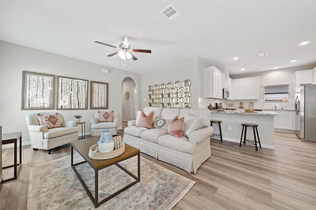 living room with ceiling fan, light hardwood / wood-style flooring, and sink