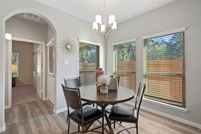 dining space featuring light hardwood / wood-style flooring and a chandelier