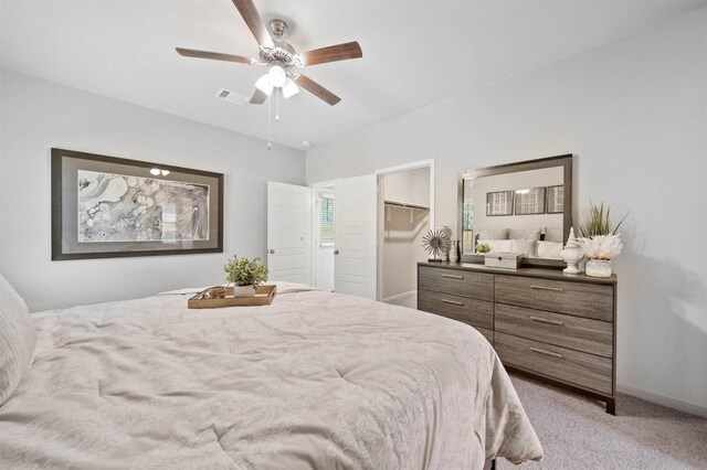 carpeted bedroom with a spacious closet, a closet, and ceiling fan