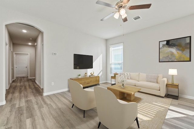 living room with light wood-type flooring and ceiling fan