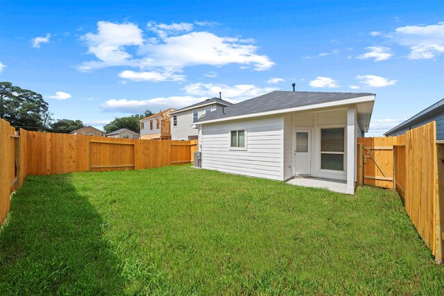 rear view of house featuring a lawn