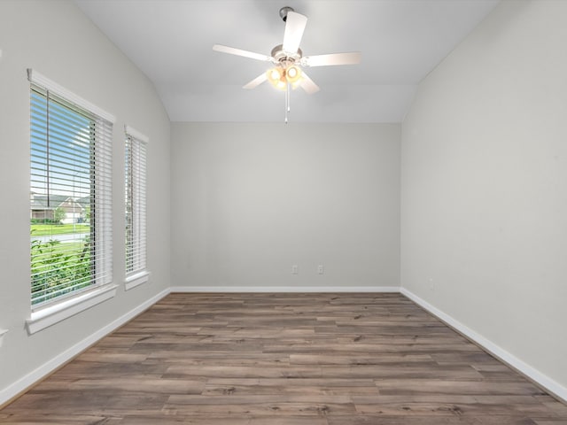 spare room with dark hardwood / wood-style flooring, vaulted ceiling, and ceiling fan