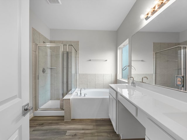 bathroom with vanity, shower with separate bathtub, and hardwood / wood-style floors