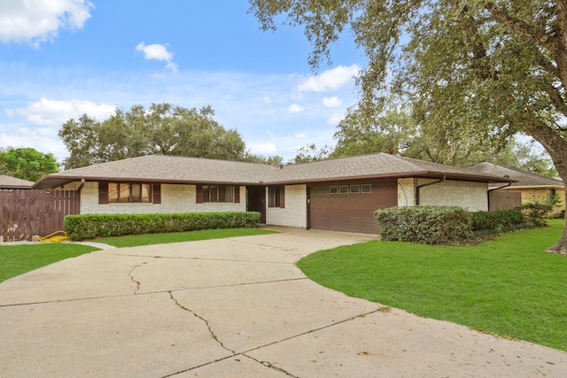 ranch-style house featuring a garage and a front yard