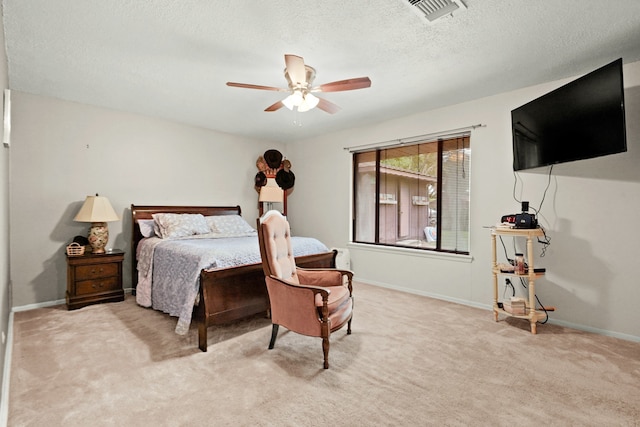 carpeted bedroom with ceiling fan and a textured ceiling